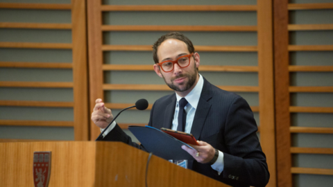 Glenn Cohen speaks to an audience from a podium