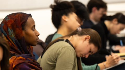 Undergraduates take notes in a lecture hall