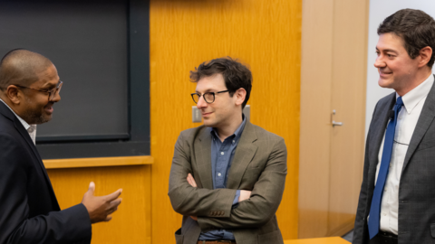A visiting fellow speaks with a guest lecturer and Center Director Eric Beerbohm in an auditorium