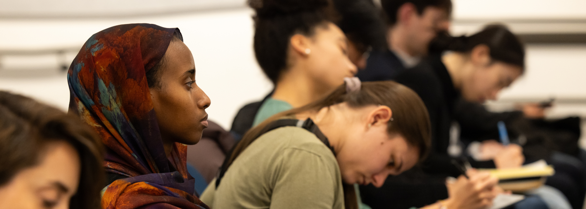 Undergraduates take notes in a lecture hall