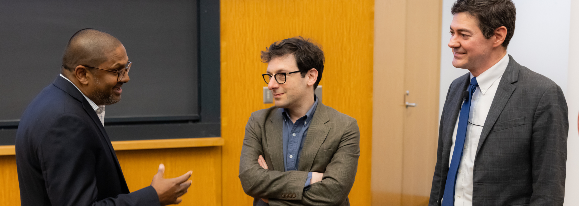 A visiting fellow speaks with a guest lecturer and Center Director Eric Beerbohm in an auditorium