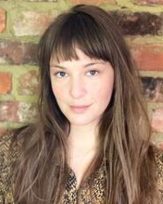 head shot of a woman with light skin and long brown hair