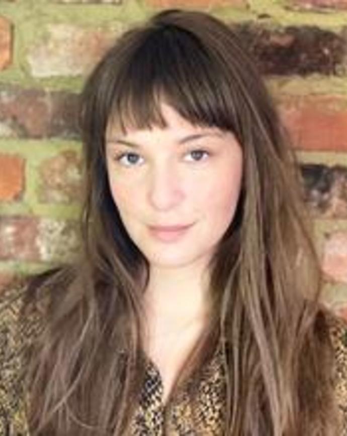 head shot of a woman with light skin and long brown hair
